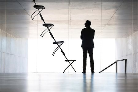 Businessman examining office chair installation art Photographie de stock - Premium Libres de Droits, Code: 6113-07242194