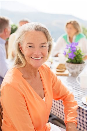 simsearch:6113-07241982,k - Senior woman smiling at patio table Photographie de stock - Premium Libres de Droits, Code: 6113-07242121