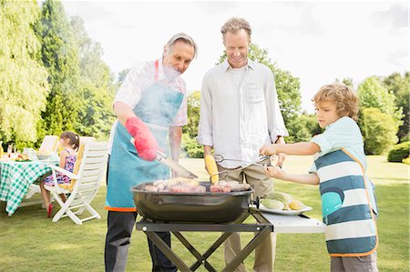 simsearch:6113-07242299,k - Men grilling meat on barbecue in backyard Photographie de stock - Premium Libres de Droits, Code: 6113-07242299