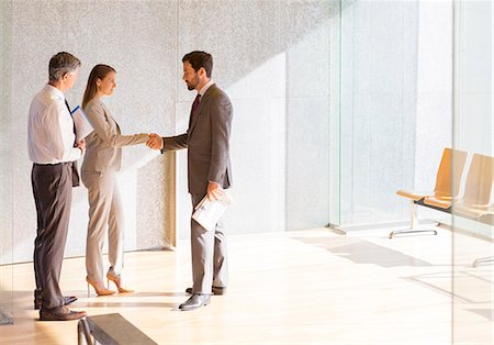 simsearch:6113-07543445,k - Business people shaking hands in sunny office lobby Stock Photo - Premium Royalty-Free, Code: 6113-07242221