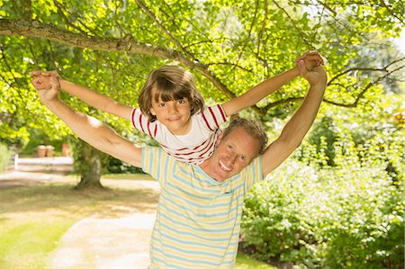 piggy back ride - Father piggybacking son under tree Photographie de stock - Premium Libres de Droits, Code: 6113-07242346