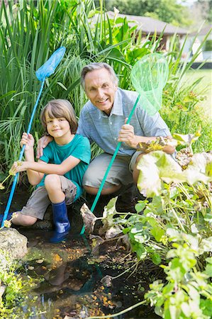 person kneeling in the creek - Grandfather and grandson fishing in pond Stock Photo - Premium Royalty-Free, Code: 6113-07242348