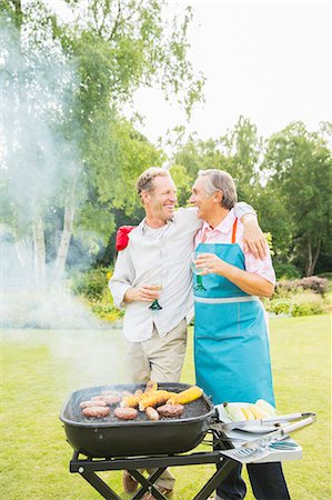 Men hugging at barbecue in backyard Stock Photo - Premium Royalty-Free, Code: 6113-07242372