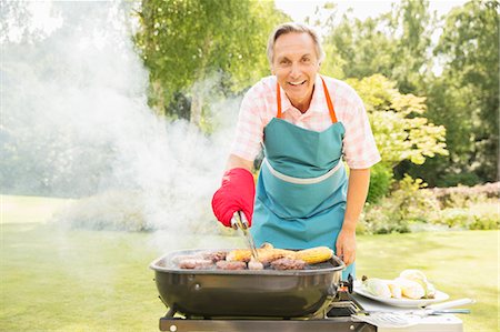 Man grilling food on barbecue in backyard Stock Photo - Premium Royalty-Free, Code: 6113-07242397