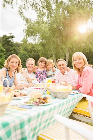 Multi-generation family eating lunch at table in backyard Stock Photo - Premium Royalty-Free, Code: 6113-07242303