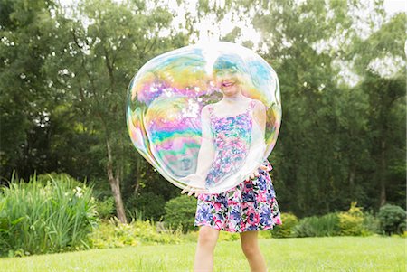 furta-cor - Father and daughter playing with large bubbles in backyard Foto de stock - Royalty Free Premium, Número: 6113-07242306