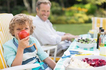 eat healthy - Boy playing with food at table in backyard Stock Photo - Premium Royalty-Free, Code: 6113-07242311