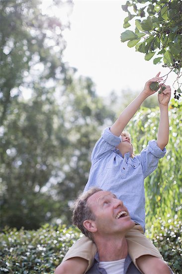 Father carrying son on shoulders outdoors Stock Photo - Premium Royalty-Free, Image code: 6113-07242407