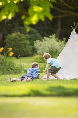 pictures of man in 50s in garden - Father and son laying outside teepee Stock Photo - Premium Royalty-Free, Code: 6113-07242434