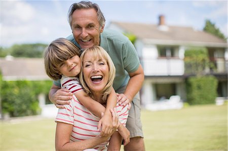 simsearch:614-06624144,k - Grandparents and grandson hugging in backyard Photographie de stock - Premium Libres de Droits, Code: 6113-07242435