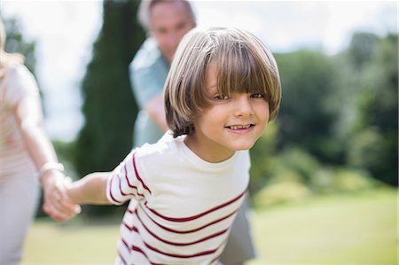 playing with grandchildren - Grandparents pulling grandparents outdoors Foto de stock - Sin royalties Premium, Código: 6113-07242436