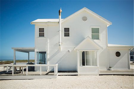 simsearch:649-08988159,k - White beach house against blue sky Photographie de stock - Premium Libres de Droits, Code: 6113-07242569