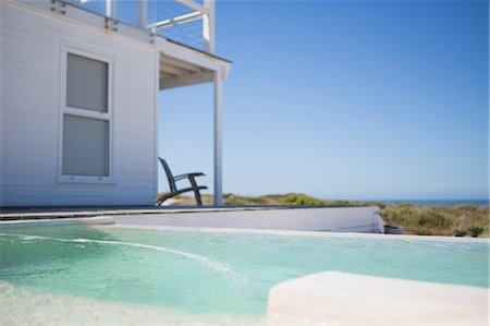 strandhaus - Infinity pool and beach house overlooking ocean Stockbilder - Premium RF Lizenzfrei, Bildnummer: 6113-07242573