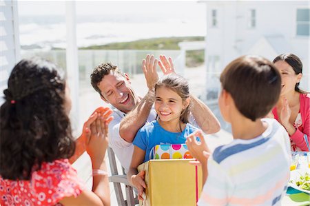 father holding son in lap - Family celebrating birthday on sunny patio Stock Photo - Premium Royalty-Free, Code: 6113-07242577