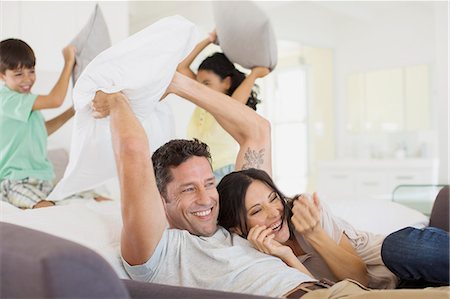 Family enjoying pillow fight in living room Stock Photo - Premium Royalty-Free, Code: 6113-07242588