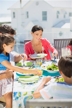simsearch:400-04792006,k - Family eating lunch at table on sunny patio Stock Photo - Premium Royalty-Free, Code: 6113-07242515