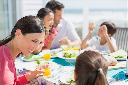 simsearch:6113-07242577,k - Family eating lunch at table on sunny patio Stock Photo - Premium Royalty-Free, Code: 6113-07242523