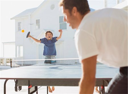 sunlight fun outdoor game - Father and son playing table tennis outdoors Stock Photo - Premium Royalty-Free, Code: 6113-07242530