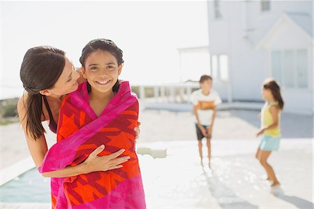 Mother wrapping daughter in towel at poolside Foto de stock - Sin royalties Premium, Código: 6113-07242535