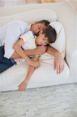 Father and son napping on sofa in living room Photographie de stock - Premium Libres de Droits, Code: 6113-07242660