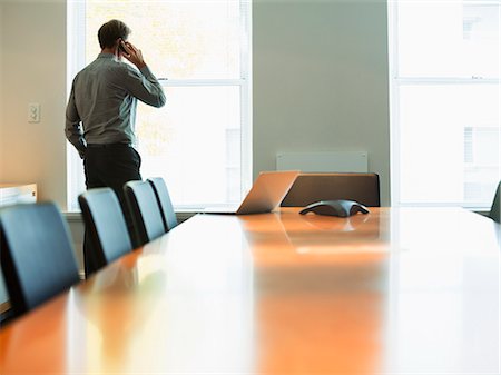 simsearch:6113-06908861,k - Businessman talking on cell phone in conference room Stock Photo - Premium Royalty-Free, Code: 6113-07242677