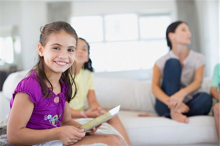 Girl using digital tablet on sofa in living room Stock Photo - Premium Royalty-Free, Code: 6113-07242623