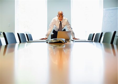 Businessman using laptop at conference table Stock Photo - Premium Royalty-Free, Code: 6113-07242757