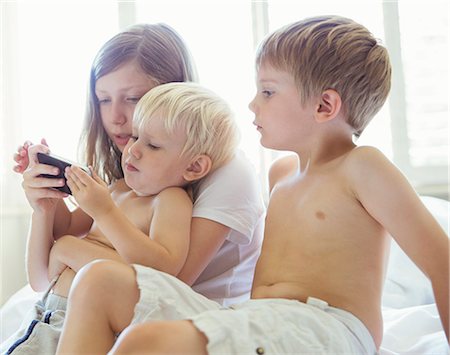 frère - Children using cell phone together Photographie de stock - Premium Libres de Droits, Code: 6113-07242790