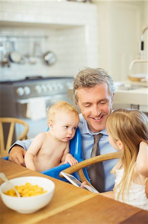 simsearch:6108-06907104,k - Father talking to children at breakfast Foto de stock - Sin royalties Premium, Código: 6113-07242796