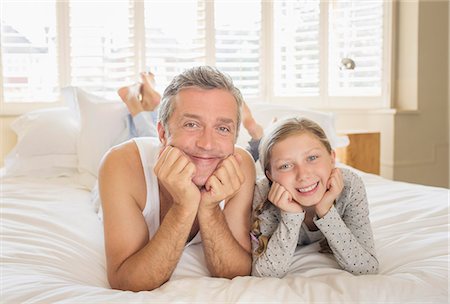 preteen girl bedroom - Father and daughter laying on bed Stock Photo - Premium Royalty-Free, Code: 6113-07242847