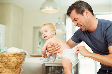 dad standing with baby - Father checking baby's diaper Stock Photo - Premium Royalty-Free, Code: 6113-07242862