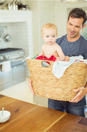 father baby smile - Father carrying baby in laundry basket Stock Photo - Premium Royalty-Free, Code: 6113-07242876