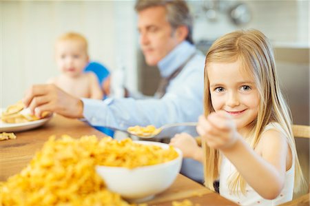 Girl eating overflowing bowl of cereal Stock Photo - Premium Royalty-Free, Code: 6113-07242884