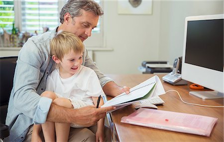 papa multitasking - Son sitting on working father's lap Stock Photo - Premium Royalty-Free, Code: 6113-07242823