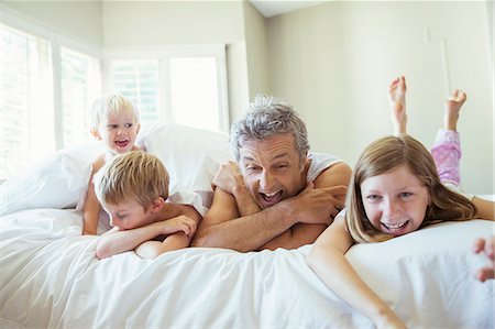 père - Father and children relaxing on bed Photographie de stock - Premium Libres de Droits, Code: 6113-07242941