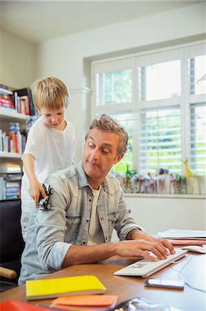 paper work - Boy distracting father at work in home office Photographie de stock - Premium Libres de Droits, Code: 6113-07242978