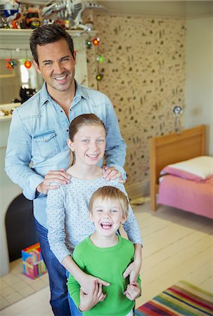 daughter on dads shoulder - Father and children smiling in bedroom Stock Photo - Premium Royalty-Free, Code: 6113-07242996