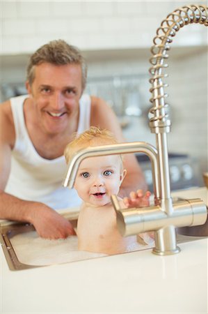 simsearch:6113-07242866,k - Father bathing baby in kitchen sink Stock Photo - Premium Royalty-Free, Code: 6113-07242906