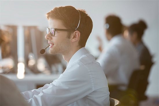 Businessman wearing headset in office Stock Photo - Premium Royalty-Free, Image code: 6113-07243059