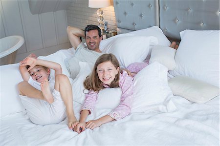 pyjamas (sleepwear with pants) - Father and children relaxing on bed Stock Photo - Premium Royalty-Free, Code: 6113-07243014