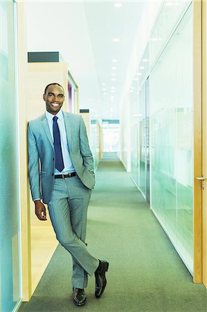 successful businessman standing photo - Businessman smiling in office Stock Photo - Premium Royalty-Free, Code: 6113-07243250