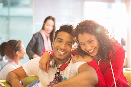 eye contact man portrait - Young couple smiling in student lounge Stock Photo - Premium Royalty-Free, Code: 6113-07243297