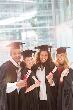 Smiling graduates holding diplomas Foto de stock - Royalty Free Premium, Número: 6113-07243346