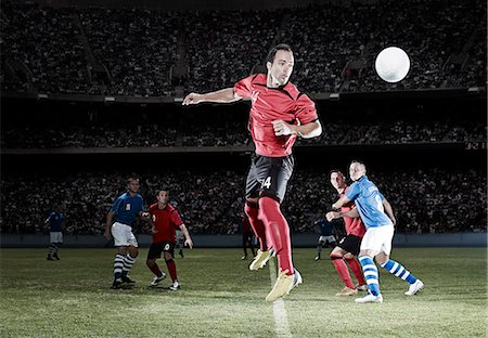 simsearch:6113-07588869,k - Soccer player jumping on field Photographie de stock - Premium Libres de Droits, Code: 6113-07310547