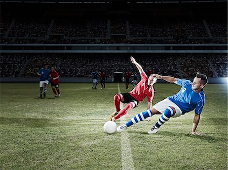 simsearch:6113-07310556,k - Soccer players kicking for ball on field Photographie de stock - Premium Libres de Droits, Code: 6113-07310546