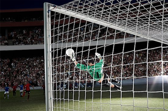 Goalie defending soccer net on field Stock Photo - Premium Royalty-Free, Image code: 6113-07310548