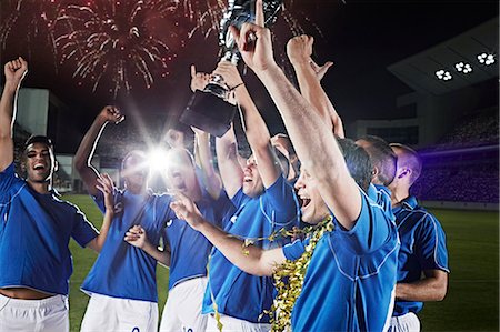 Soccer team cheering with trophy on field Photographie de stock - Premium Libres de Droits, Code: 6113-07310553