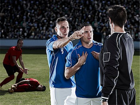 simsearch:6113-07588877,k - Soccer players arguing with referee on field Foto de stock - Sin royalties Premium, Código: 6113-07310569