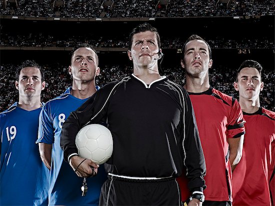 Soccer teams and referee standing in stadium Stock Photo - Premium Royalty-Free, Image code: 6113-07310572
