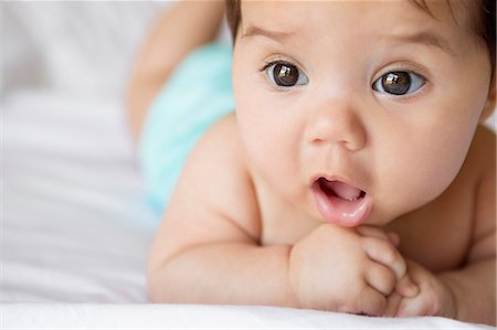 Baby girl laying on bed Foto de stock - Sin royalties Premium, Código: 6113-07542382